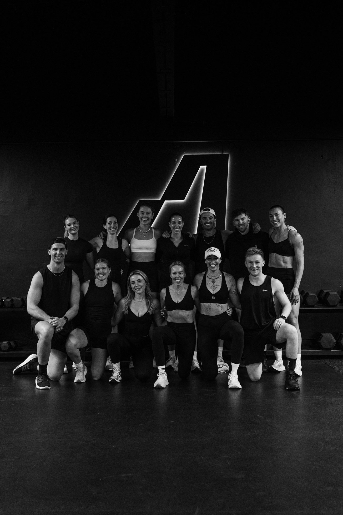 The Assembly coaches and members together on the training floor under the lit A logo